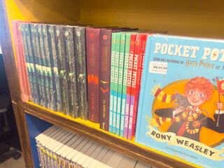 Fototapeta premium BELO HORIZONTE, MG, BRAZIL – NOVEMBER, 26, 2025: A shelf displaying various editions of Harry Potter books by J.K. Rowling, including Pocket Potters, in a bookstore.