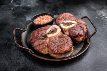 Deliciously braised ossobuco, featuring tender osso buco veal shank and rich marrow, perfect for a gourmet Italian feast. black background. top view