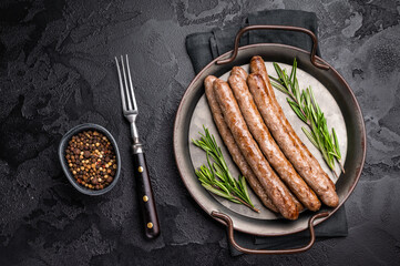 Juicy grilled sausage sizzling on the barbecue, perfect for summer cookouts and outdoor gatherings. black background. top view