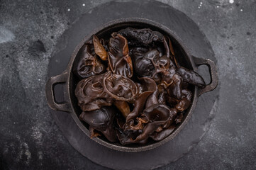 A bowl of fresh wood ear mushrooms, perfect for health conscious cooks seeking nutritious and flavorful ingredient. black background. top view
