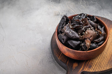 Organic wood ear mushrooms on a wooden cutting board, showcasing their unique shape and rich culinary potential. white background. top view