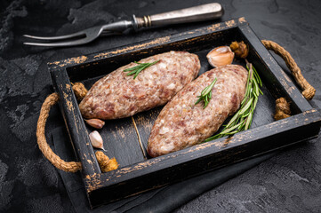 Raw kebabs or kabaps on wooden tray, beautifully arranged and ready to be cooked for a delicious outdoor feast. black background. top view