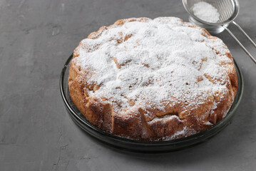 Homemade pie with apples and pumpkin dusted with powdered sugar