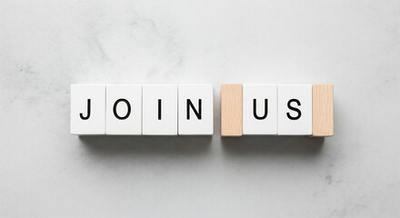 Inviting message formed by wooden blocks spelling 'JOIN US' on a textured surface
