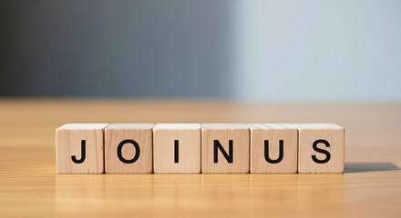 Wooden blocks spelling out "JOIN US" on a table, inviting collaboration and teamwork