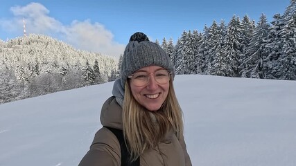 Influencer woman taking selfie video in snowy mountain forest