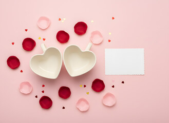 minimal valentine background with two hearts, scattered petals and blank note card