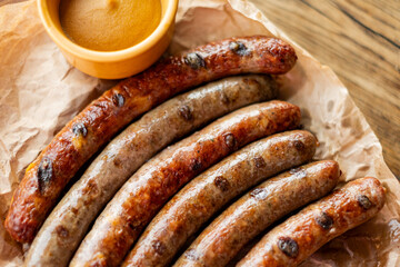 sausage on a wooden board with mustard