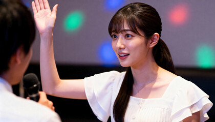 Young Asian woman raising her hand to ask a question during a business conference. Female colleague participating in a seminar or presentation. Professional communication between colleagues