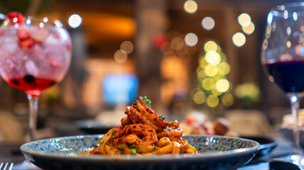 Pasta italiana con camarón y salsa boloñesa servida en plato azul 