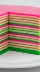 A slice of colorful layered cake with pink, green, and brown stripes.