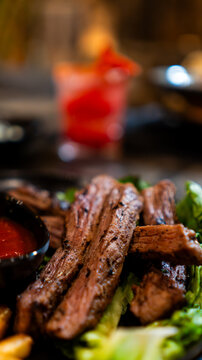 Carne asada servida con papas fritas y salsa en restaurante nocturno