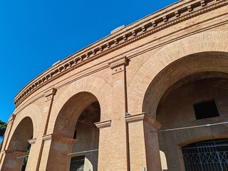 Fototapeta premium Ostia Antica, Rome, Italy - November 23, 2025, detail of the arches and perimeter brick wall of an entrance to the Roman theater in Ostia.