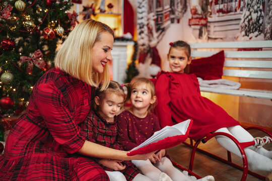 Mother reading Christmas story to children at home