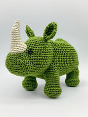 A handcrafted, charming green rhinoceros with a beige horn, perfect for cuddles and play