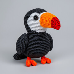 A charming crocheted toucan bird standing. The toy bird is crafted with vibrant colors and details, capturing its distinctive beak and expressive eyes