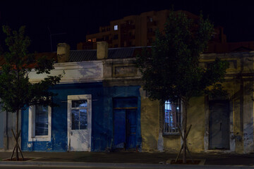 Old colorful city houses at night with trees and apartment block