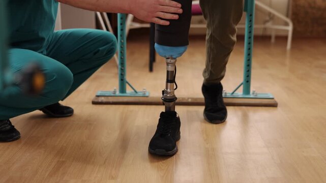 physical therapy, rehabilitation center, organized space. Man with prosthetic leg receives physical therapy from medical expert, using parallel bars to help him walk in rehabilitation facility