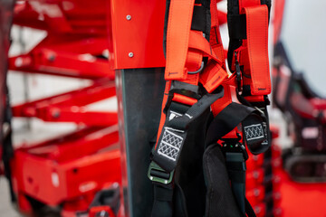 Protective work harness system mounted on heavy-duty lift section at indoor construction technology exhibition focused on height-safety equipment