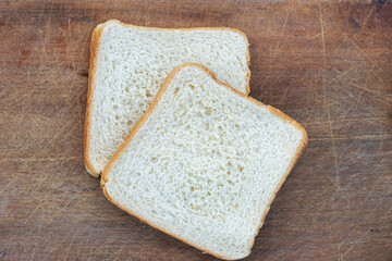 Soft and fresh slices of white bread on a rustic wooden board. Ideal for a healthy breakfast. Space for text.