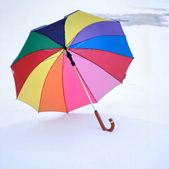 Colorful umbrella standing in the snow, creating a vibrant contrast in a winter landscape