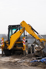 Yellow backhoe loader excavator at a construction site