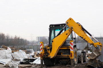 Fototapeta premium Yellow backhoe loader excavator at a construction site