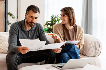 Couple managing home finances, reviewing budget and bills