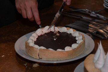 Primer plano de postres dulces en mesa en fiesta, cuchillo cortando porción