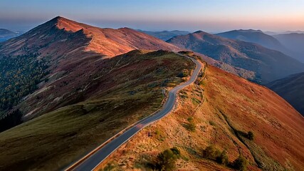 Stunning aerial journey along a winding mountain road at sunrise, perfect for travel ads or inspirational videos