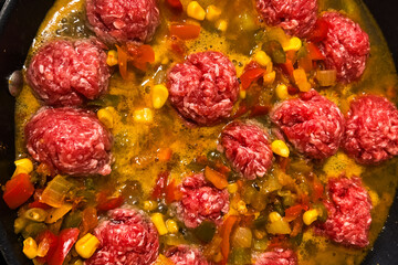 Beef meatballs simmering in a flavorful vegetable stew with vibrant colors