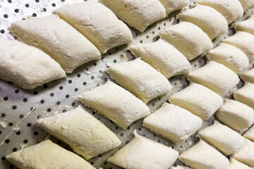 Homemade dough pieces arranged on a tray ready for cooking in a cozy kitchen