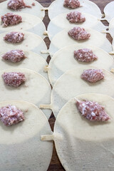 Preparing dumplings with meat filling for a family meal in a cozy kitchen