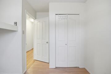 White room with a white door and a white closet