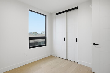 White room with a window and a white closet
