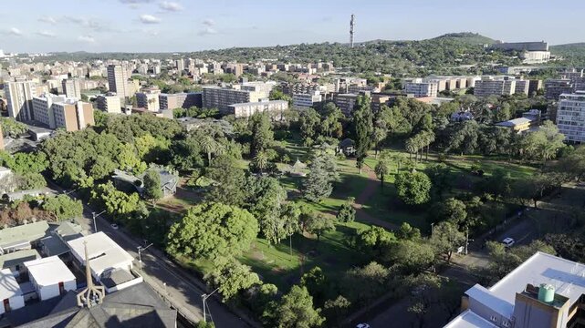 Drone flies southeast toward Burgers Park on sunny afternoon in Pretoria, South Africa