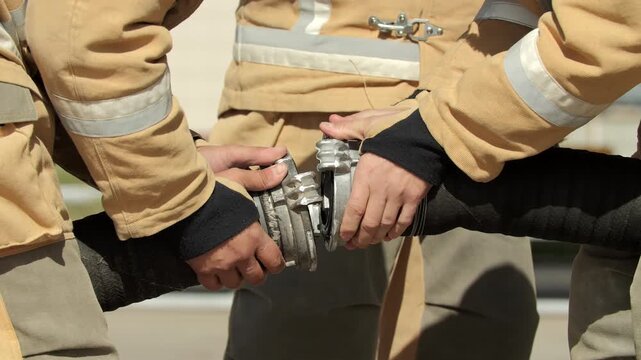 Firefighters Connecting Heavy Water Hose