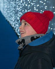 Boy in Red Pom-Pom Hat Looking at Christmas Lights
