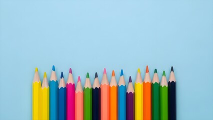 Colorful pencils arranged on a light blue background with copy space