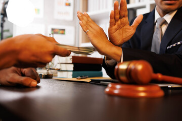 A man is giving money to another man, but the other man is refusing it. The scene is set in a...