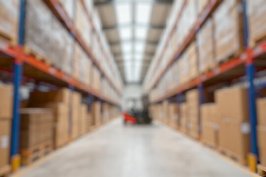 forklift in warehouse with shelves of boxes. blurred image background.