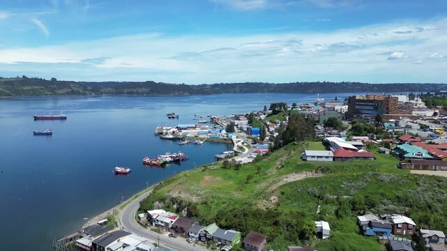 Castro, Chile: Aerial drone footage above colorful waterfront stilt houses in Castro, Chiloe island, Lake District of Chile. Taken with backward motion on a sunny day