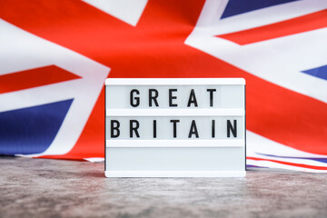 Minimal patriotic scene with signboard and waving flag message UNITED KINGDOM with national colors Festive background with British flag and message board with text Great Britain. Remembrance Day