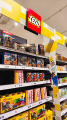 Naklejka premium Potsdam, Germany - October 21, 2025: LEGO toy display in a retail store showcasing various colorful building sets and creative play options for children and enthusiasts