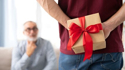 Young man surprises senior father with wrapped gift for special occasion
