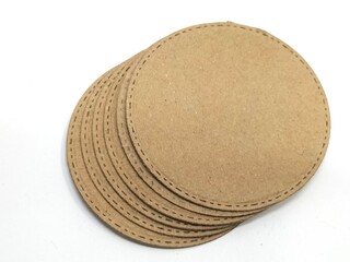 stack of brown cardboard coasters with stitching detail