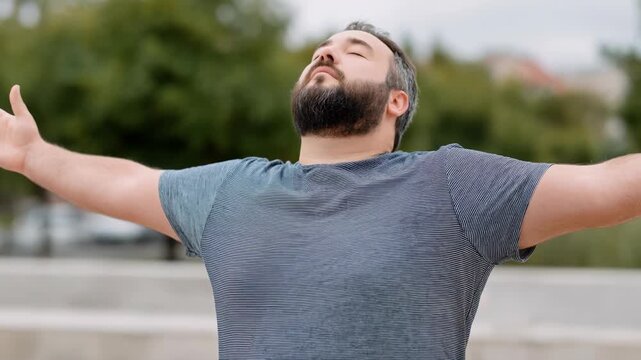 Man beard adult male portrait outdoors relaxation breathing stretching arms enjoying breeze calm expression meditating arms outstretched relaxed