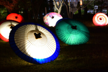 夜の庭園を彩る和傘ライトアップの幻想的な光景