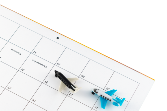 Toy airplanes on a December calendar date showing busy travel days at the holiday