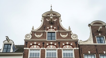Closeup of the ornate facade of a historic dutch building, featuring intricate brickwork, decorative gables, and multipaned windows, showcasing traditional architecture